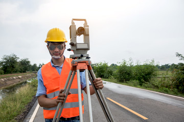 Young man engineer is using Surveyor equipment tacheometer or theodolite worker on the road.