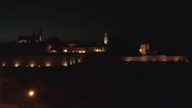 The city in Poland at night. The view from drone that is taking off and climbing showing the beautiful old city hall from above.