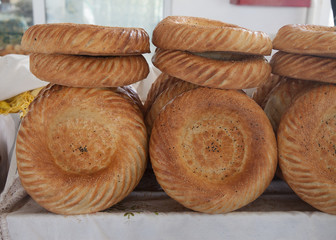 A lot of uhbek tandoor cakes for sale in close-up. Horizontally.