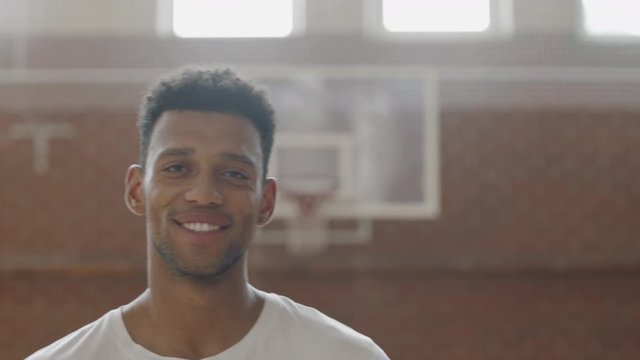 CU Portrait of young confident African American black college basketball player pointing a ball into camera. Shot on ARRI Alexa Mini, 4K RAW graded footage
