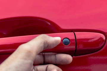 Asian man opens red car door with smart keyless For automotive or transportation image