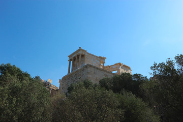 Fototapeta na wymiar View to famous greek ancient landmark Propylaea of the Athenian Acropolis against a bright blue sky