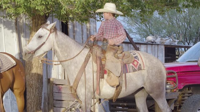 Cowboy Riding Horse, Testing Sturdiness Of His Saddle Before The Ride.
