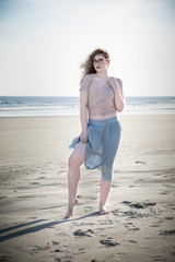 young woman being blown in the wind on beach