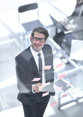 top view.businessman reading sticky notes on the glass.