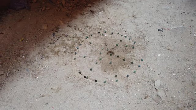 Kanche is a popular game in rural Southeast Asia and India, played with round glass marbles and aim is to collect as many as possible by shooting and striking other marbles. 4k 60fps handheld close-up
