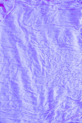 Soft violet colored creased fabric texture abstract background. Top view folded backdrop with copy space for text
