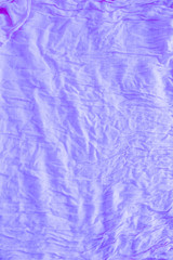 Fototapeta premium Soft violet colored creased fabric texture abstract background. Top view folded backdrop with copy space for text