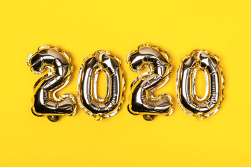 Golden foil balloons on yellow background. Inflatable numbers 2020. Christmas concept