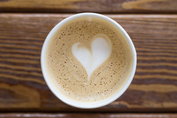 Coffee cup with heart shape latte art on wooden table. Love, Valentine's Day concept. Top view, flat lay, copy space