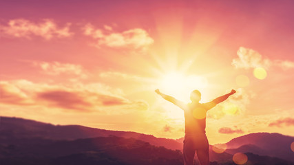 Copy space of man rise hand up on top of mountain and sunset sky abstract background.