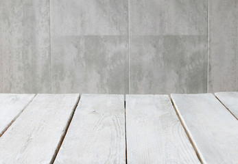 White wooden table top and grey stone wall in the background