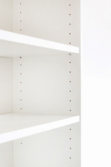 Empty shelf in white cupboard.