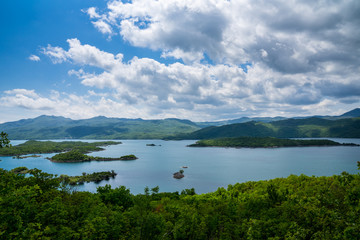 Fototapeta na wymiar Montenegro, Endless green hills and mountains covered by trees and forest surrounding seascape of lake slano near niksic in a beautiful nature landscape from above
