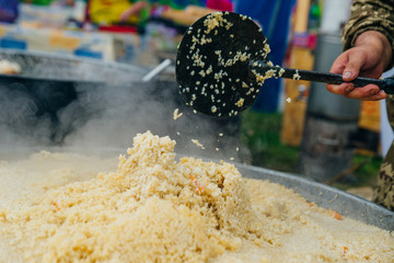 Real Uzbek pilaf in a huge cauldron. Cooking national dishes.