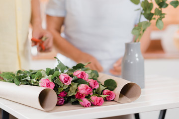 Asian elderly couple making bouquet flowers on a wooden table in kitchen at home. Chinese sweet senior couple using time relax together at home. Lifestyle senior couple at home concept.