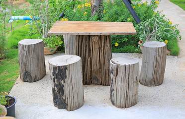 Fototapeta premium Wood table and chair set in garden. Garden furniture made from wooden log.