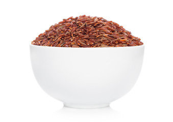 White bowl of raw organic red rice on white background. Healthy food.