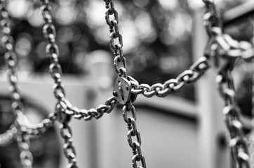 Rows of shining metal chains with beautiful bokeh stylized black and white film