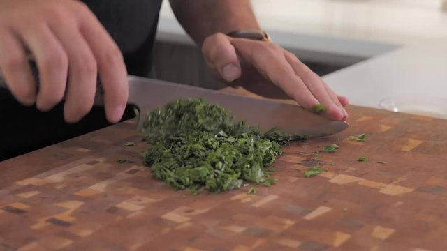 CLOSE UP parsley being chopped in preparation for tabouleh. REAL TIME