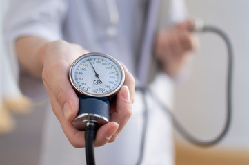 nurse holds tonometer in hands, arrow shows high pressure, closeup of tonometer display