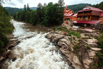 Obraz premium Small green forest waterfall in the cave mountains, cascades on a mountain river. The concept of active holidays, holidays