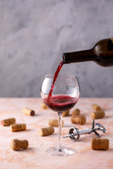 Red wine is poured into a glass. The concept of winemaking. Place under your text.