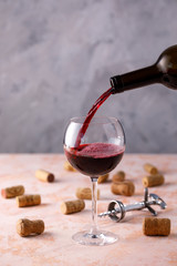 Red wine is poured into a glass. The concept of winemaking. Place under your text.