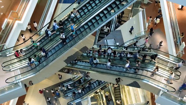 Time lapse of crowd of people in shopping mall. Escalators in modern shopping mall.