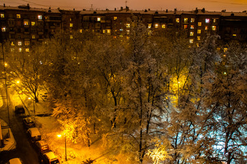 View of the night winter yard from the window of a residential building