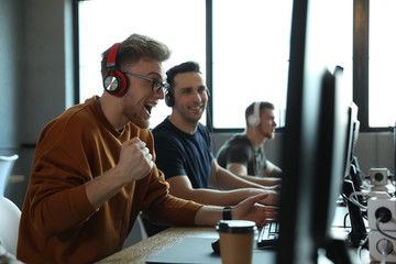 Men playing video games in internet cafe