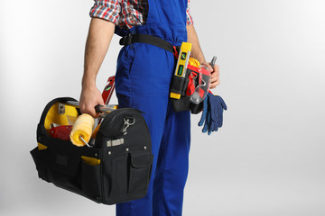 Construction worker with set of tools on light background, closeup. Space for text