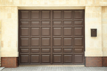 Large brown gate in modern wall of building