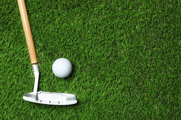 Golf ball and club on artificial grass, top view with space for text