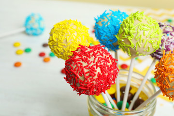 Tasty cake pops in jar on table, closeup. Space for text