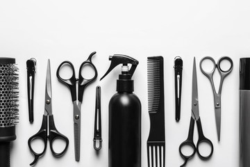 Composition with scissors and other hairdresser's accessories on white background, top view