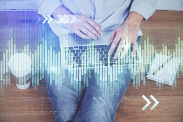 Financial forex graph drawn over hands taking notes background. Concept of research. Double exposure
