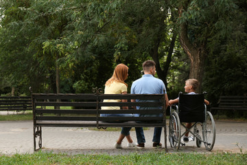 Boy in wheelchair with his family at park