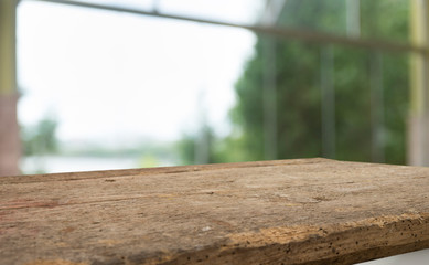 Empty of wood table top on blur of curtain with window view green from tree garden background.For...