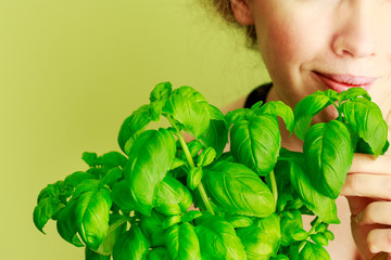 Woman holding basil plant.