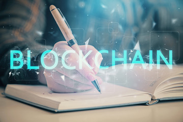 Cryptocurrency hologram over woman's hands writing background. Concept of blockchain. Double...