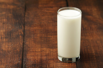 A glass with milk on a wooden rustic table