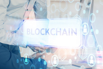 Crypto currency theme hologram with businessman working on computer on background. Concept of...