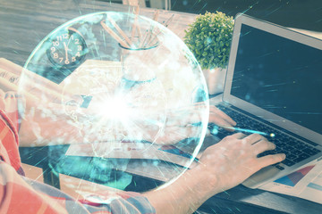 Double exposure of businessman working on laptop on background. International business hologram in front. Concept of success.