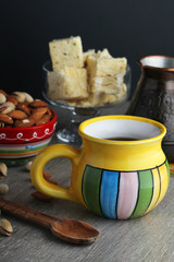 A mug of coffee and different oriental sweets: turkish delight, halva, almond and pistachio	