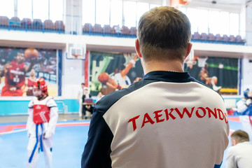 coach Taekwondo follows the fight of Taekwondo in the background of Taekwondo closeup