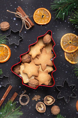 Homemade fresh cookies in a tin box Fir branches Dried slices of orange Cookie cutters Christmas concept