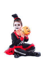 Full length of happy asian girl in halloween skeleton costume sitting over white background