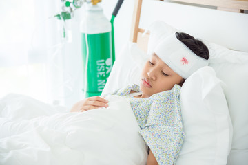 Young asian girl with head injury resting on bed in hospital