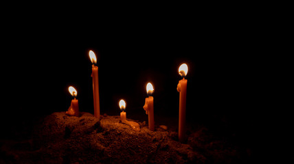 Group candlelight is bright light on sand in dark night. Religion concept